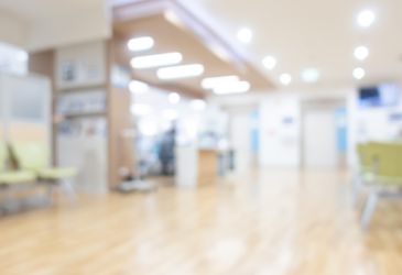 Heller Wartebereich einer Arztpraxis mit Sitzgelegenheiten, Symbolbild für Patientenversorgung und Gesundheitswesen.