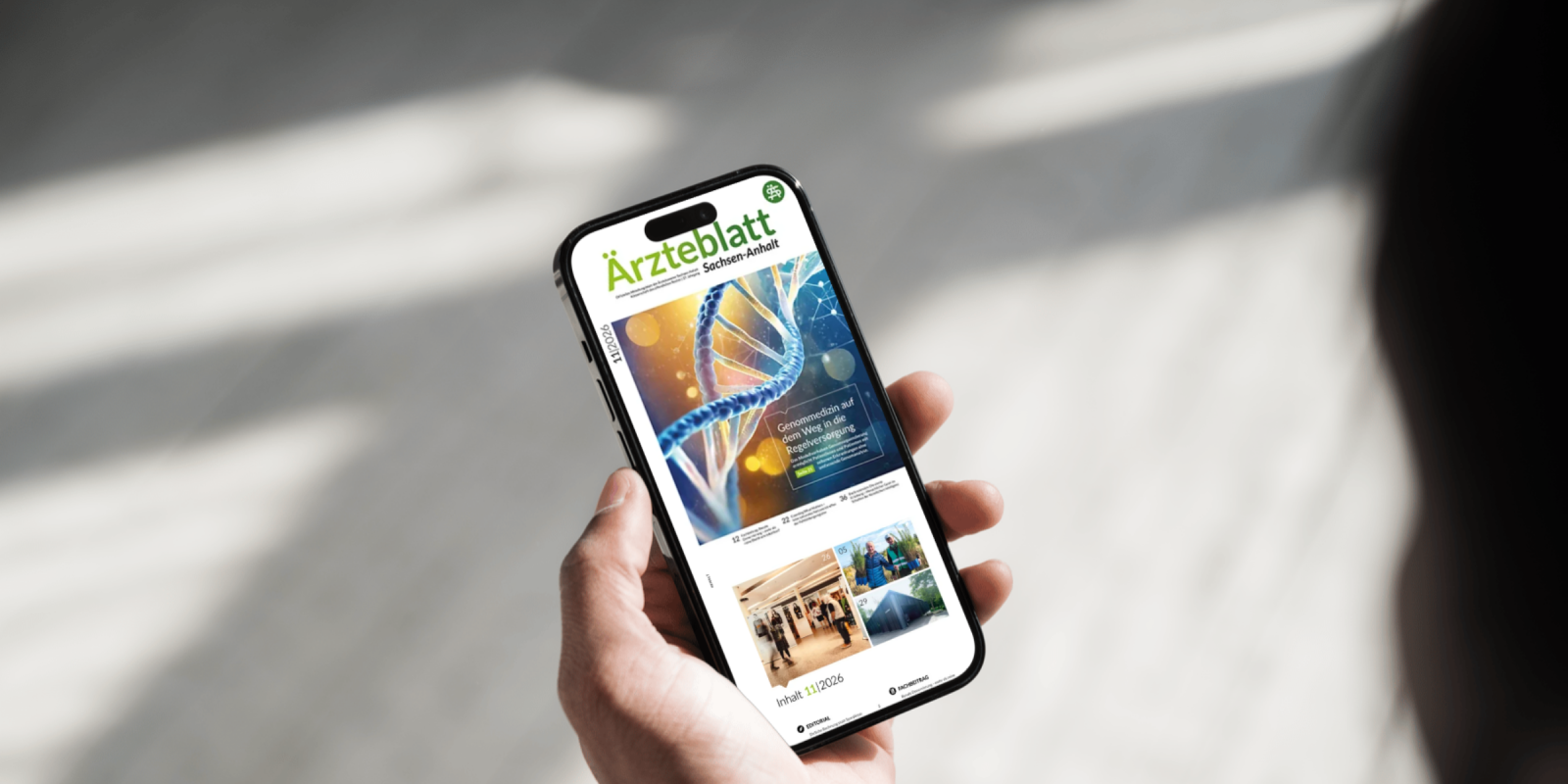 Hand hält Smartphone mit geöffneter Ausgabe des Ärzteblatts Sachsen-Anhalt auf dem Display