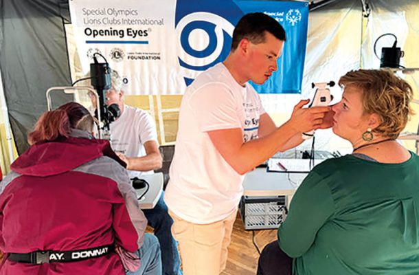 Augenuntersuchung bei Special Olympics: Arzt prüft Sehvermögen mit Handgerät im Rahmen des Programms „Opening Eyes“