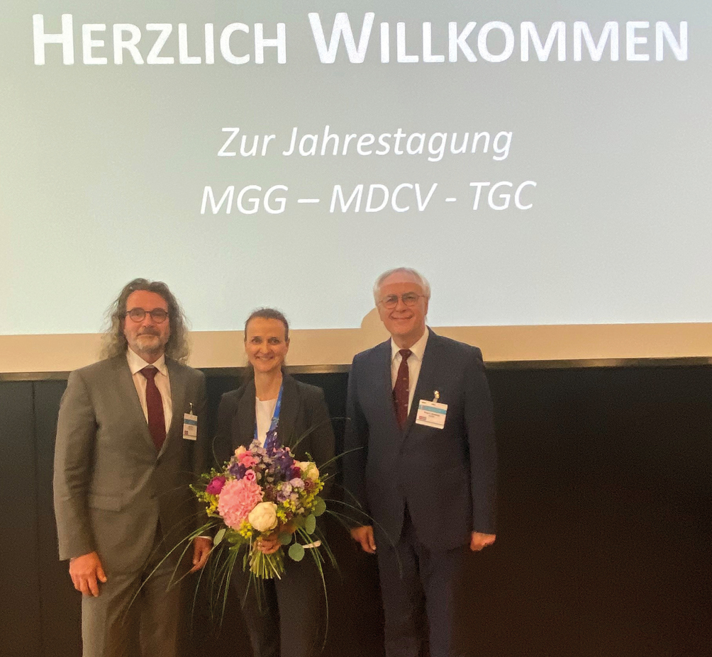 Teilnehmer eines medizinischen Kongresses betrachten gemeinsam Unterlagen und diskutieren Inhalte.