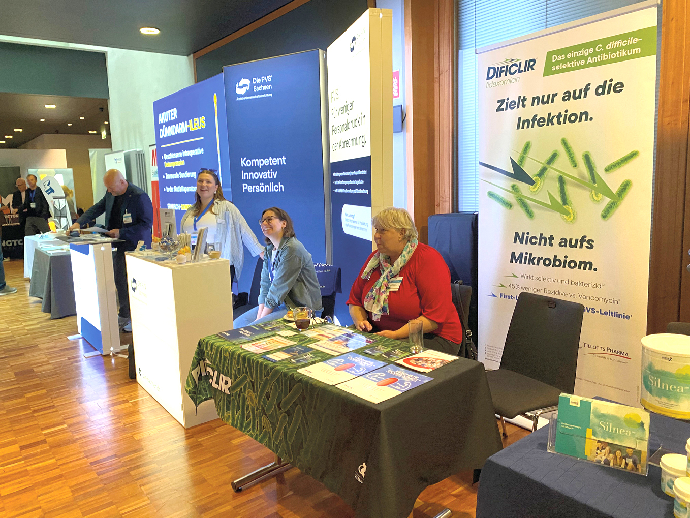 Teilnehmer eines medizinischen Fachkongresses im Gespräch, umgeben von Sitzreihen und weiteren Besucherinnen und Besuchern.