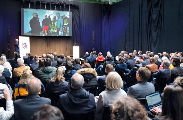 Fachvortrag beim MZKR mit Publikum und Bild von Rettungskräften im Einsatztraining