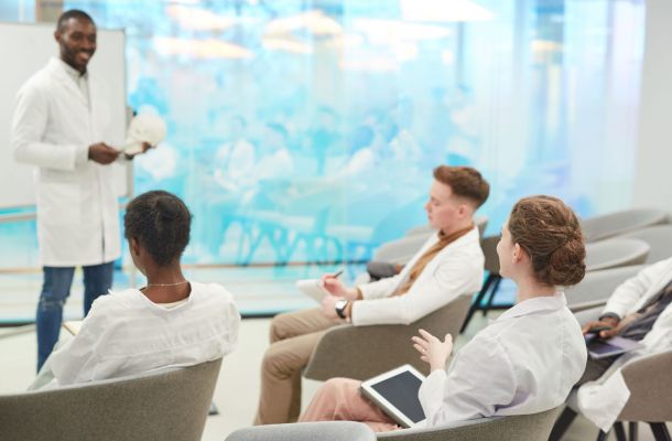 Dozent erklärt Anatomie mit Schädelmodell vor Medizinstudierenden im Seminar zur klinischen Ausbildung