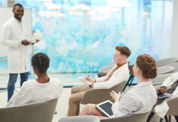 Dozent erklärt Anatomie mit Schädelmodell vor Medizinstudierenden im Seminar zur klinischen Ausbildung