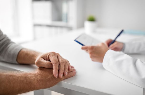Ärztliches Beratungsgespräch mit Patientenhänden und Dokumentation auf Klemmbrett