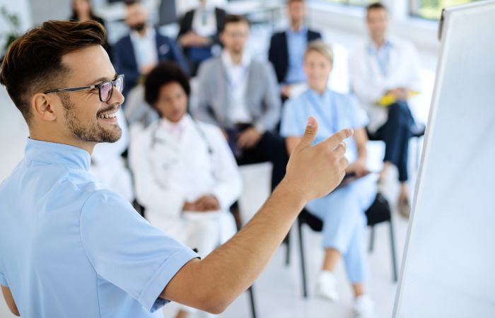 Medizinisches Team bei einer Schulung, Arzt erklärt Inhalte am Whiteboard zur Fortbildung in der Gesundheitsversorgung.