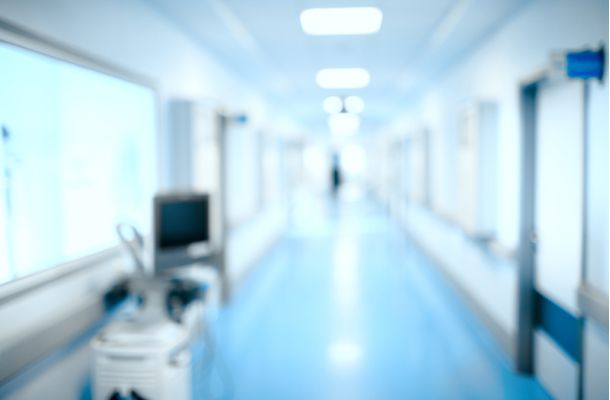 Moderner Krankenhausflur mit medizinischem Personal im Hintergrund, Symbol für Gesundheitsversorgung und Klinikalltag.