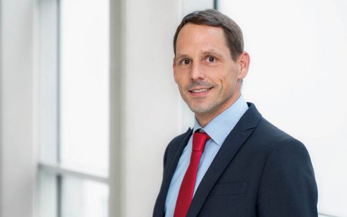 Arzt im weißen Kittel mit Stethoskop über der Schulter, Symbolbild für medizinische Versorgung und Patientenbetreuung.