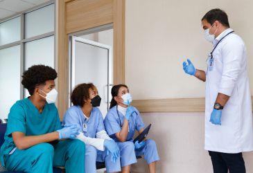 Unscharfer Krankenhausflur mit Personen im Hintergrund, Symbolbild für Klinikalltag und medizinische Versorgung