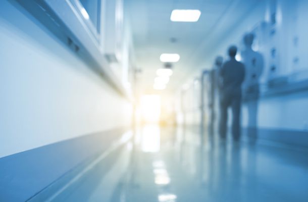 Unscharfer Krankenhausflur mit Personen im Hintergrund, Symbolbild für Klinikalltag und medizinische Versorgung