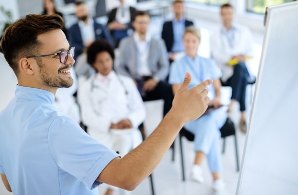 Medizinisches Team bei einer Schulung, Arzt erklärt Inhalte am Whiteboard zur Fortbildung in der Gesundheitsversorgung.