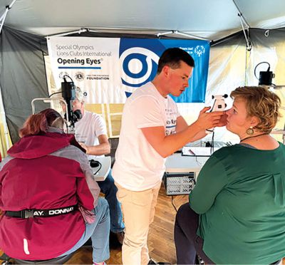 Augenuntersuchung bei Special Olympics: Arzt prüft Sehvermögen mit Handgerät im Rahmen des Programms „Opening Eyes“