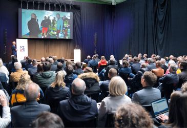 Fachvortrag beim MZKR mit Publikum und Bild von Rettungskräften im Einsatztraining