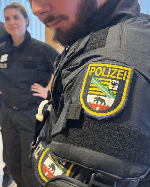 Polizeibeamter mit Abzeichen der Polizei Sachsen-Anhalt bei einer interdisziplinären Fortbildung im medizinischen Kontext.