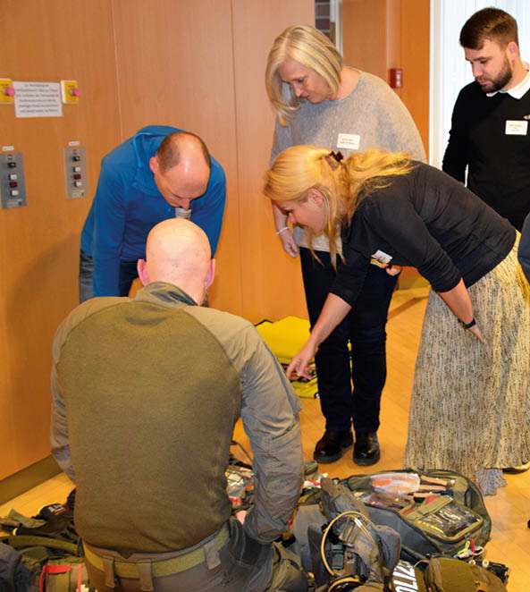 Teilnehmer einer Fortbildung prüfen gemeinsam Notfall- und Schutzausrüstung bei einer Übung zu lebensbedrohlichen Einsatzlagen.