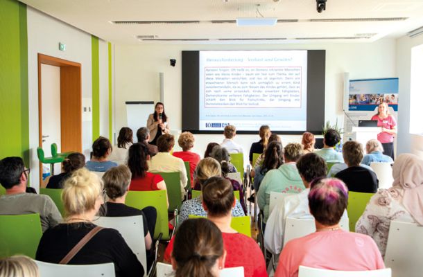 Teilnehmende beim Ethiktag lauschen einem Vortrag zu medizinisch-ethischen Herausforderungen im Konferenzraum.