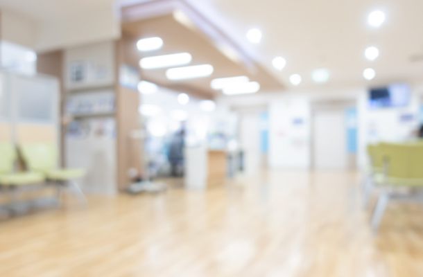 Heller Wartebereich einer Arztpraxis mit Sitzgelegenheiten, Symbolbild für Patientenversorgung und Gesundheitswesen.