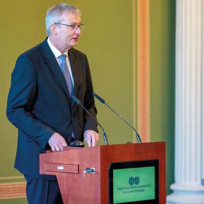 Redner am Pult bei einer medizinisch-wissenschaftlichen Veranstaltung an der Martin-Luther-Universität Halle-Wittenberg.