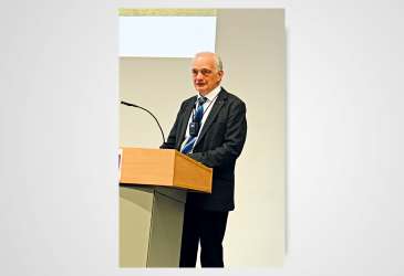 Redner am Pult während einer medizinischen Fachveranstaltung – Vortrag im Rahmen einer Tagung oder Konferenz.