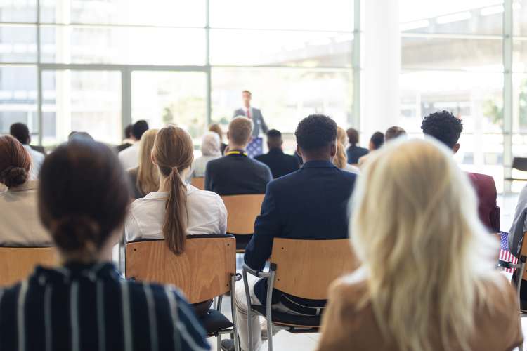 Teilnehmer hören einem Vortragenden bei einer medizinischen Fachkonferenz aufmerksam zu.