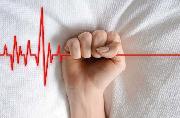 Symbolbild zu Selbstbestimmung am Lebensende: Faust hält EKG-Linie, Sinnbild für ethische Fragen zu Leben, Tod und assistiertem Suizid.