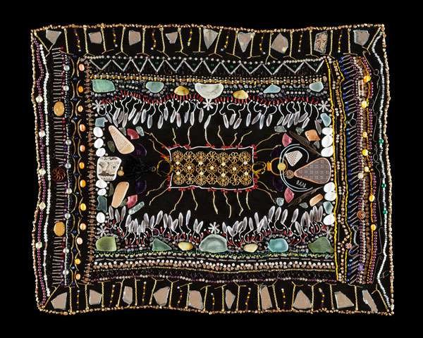 Detailreiches Kunstwerk auf schwarzem Grund mit Steinen, Perlen, Mustern und symmetrischen ornamentalen Formen.