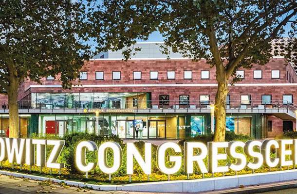 Beleuchteter Eingang des Carlowitz Congresscenters am Abend, modernes Gebäude mit großer Leuchtschrift.