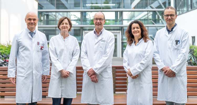 Ärzteteam im weißen Kittel vor Klinikgebäude, Experten des Sarkomzentrums Halle für interdisziplinäre Tumorbehandlung.