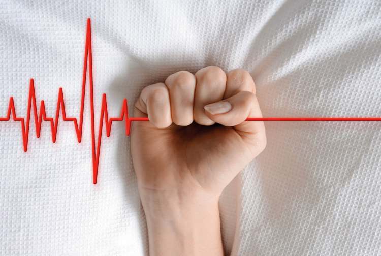 Symbolbild zu Selbstbestimmung am Lebensende: Faust hält EKG-Linie, Sinnbild für ethische Fragen zu Leben, Tod und assistiertem Suizid.