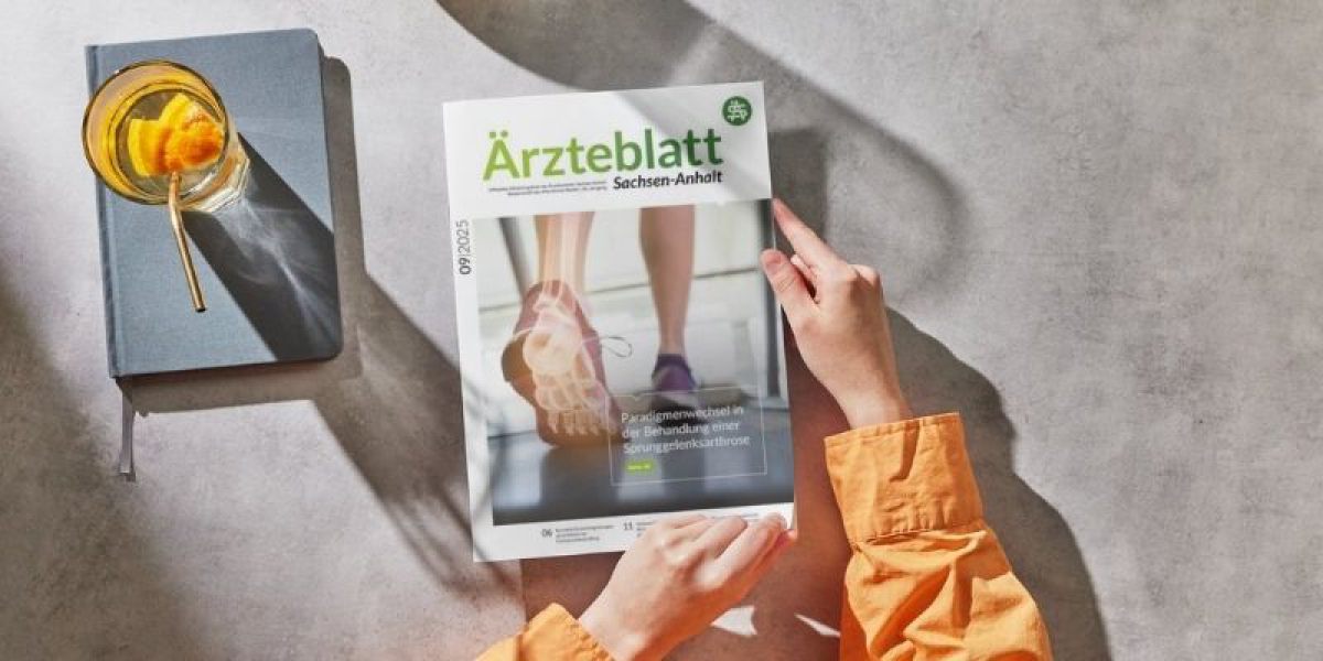 Person hält das Ärzteblatt Sachsen-Anhalt 09/2025 mit Titelthema Sprunggelenksarthrose auf einem Tisch neben einem Getränk.